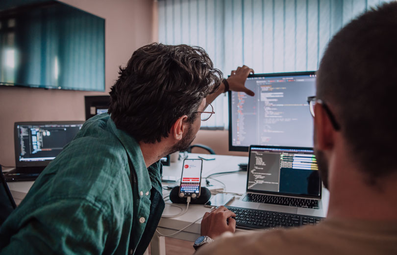 A person in a suit handling a pile a documents